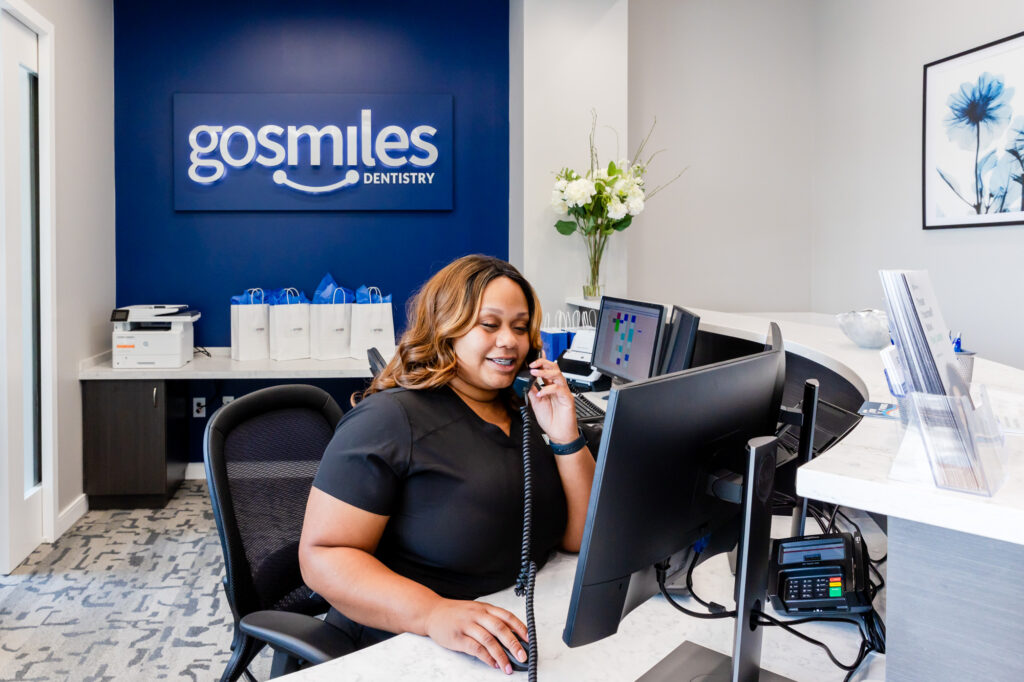 front desk assistant at our cosmetic dentistry in Herndon, VA, talking to a new patient on the phone.